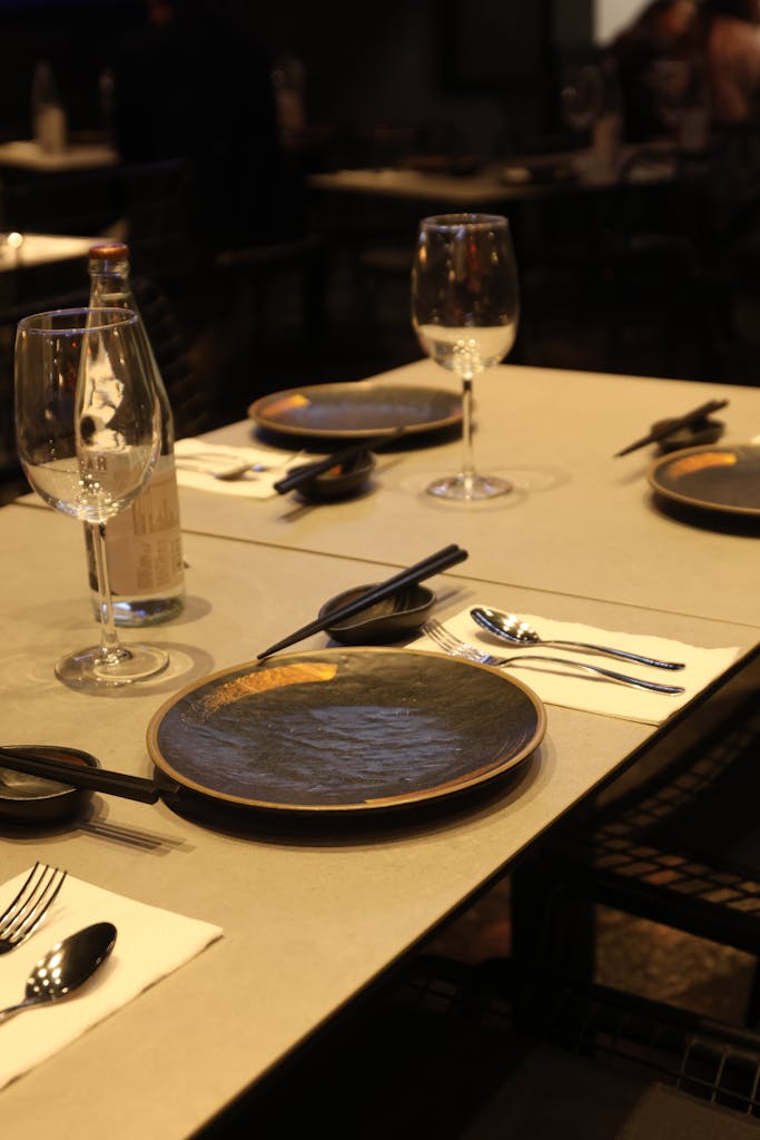 Sophisticated table setting with stylish dinnerware and wine glasses in a modern restaurant.